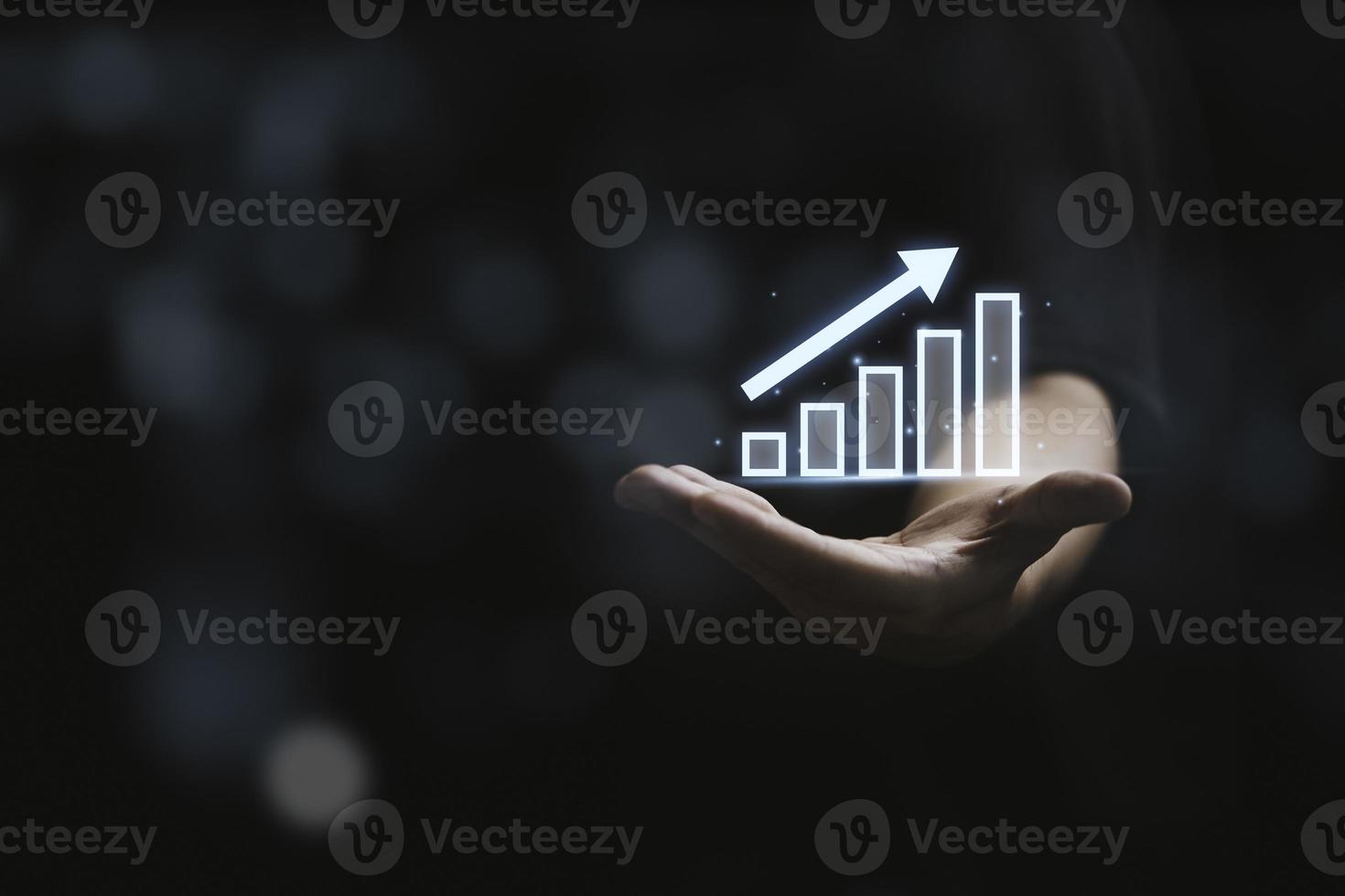 Businessman holding glowing virtual graph and stock market chart for business Growth profit concept. photo