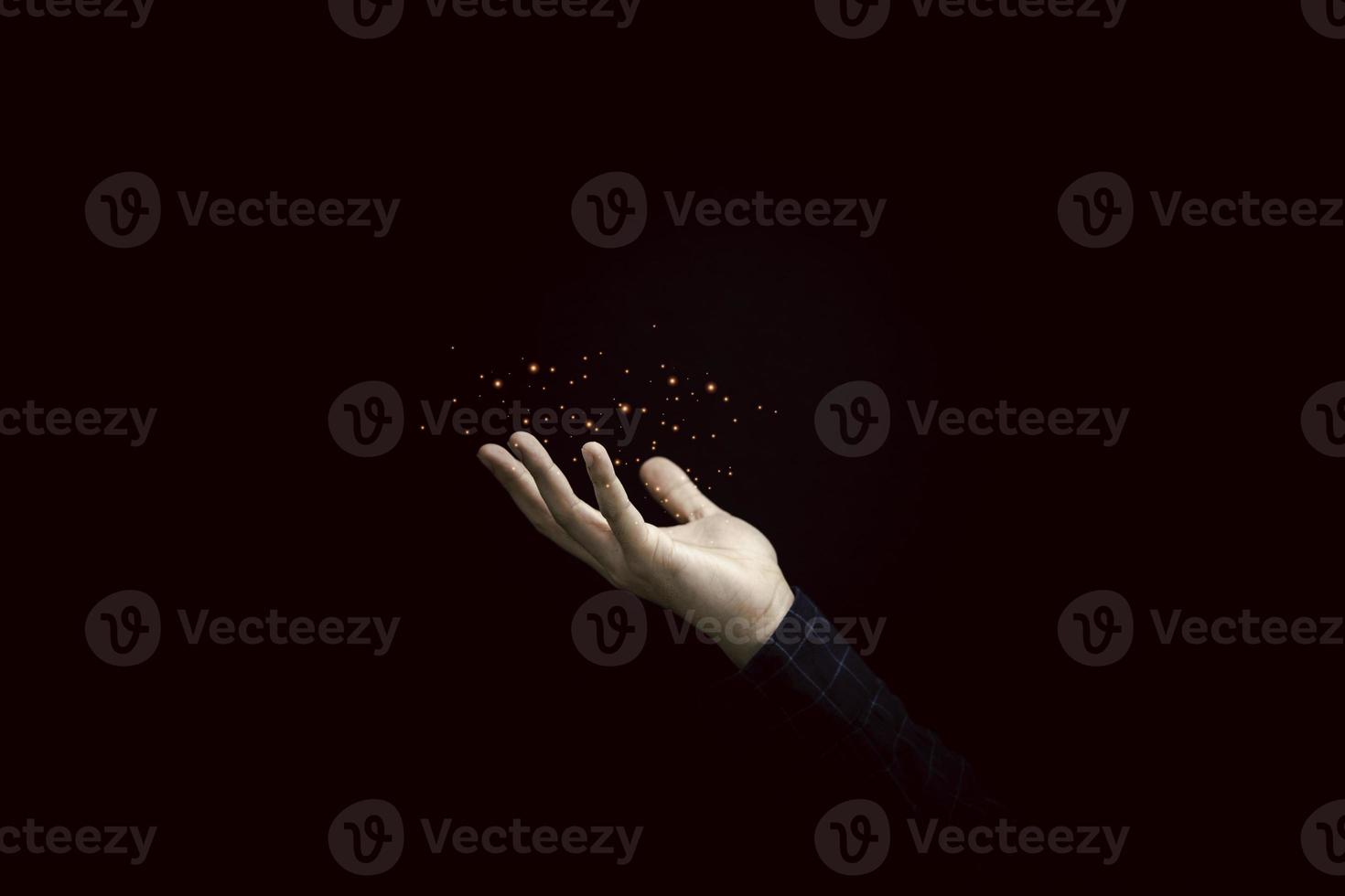 Hand holding orange light on dark background. photo