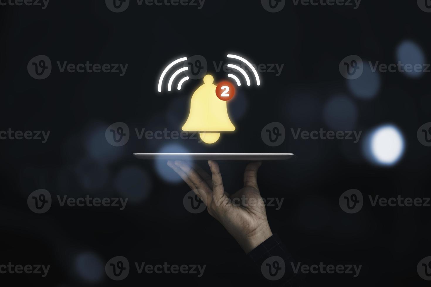 Businessman holding tablet with virtual yellow bell ringing for application notification alert concept. photo
