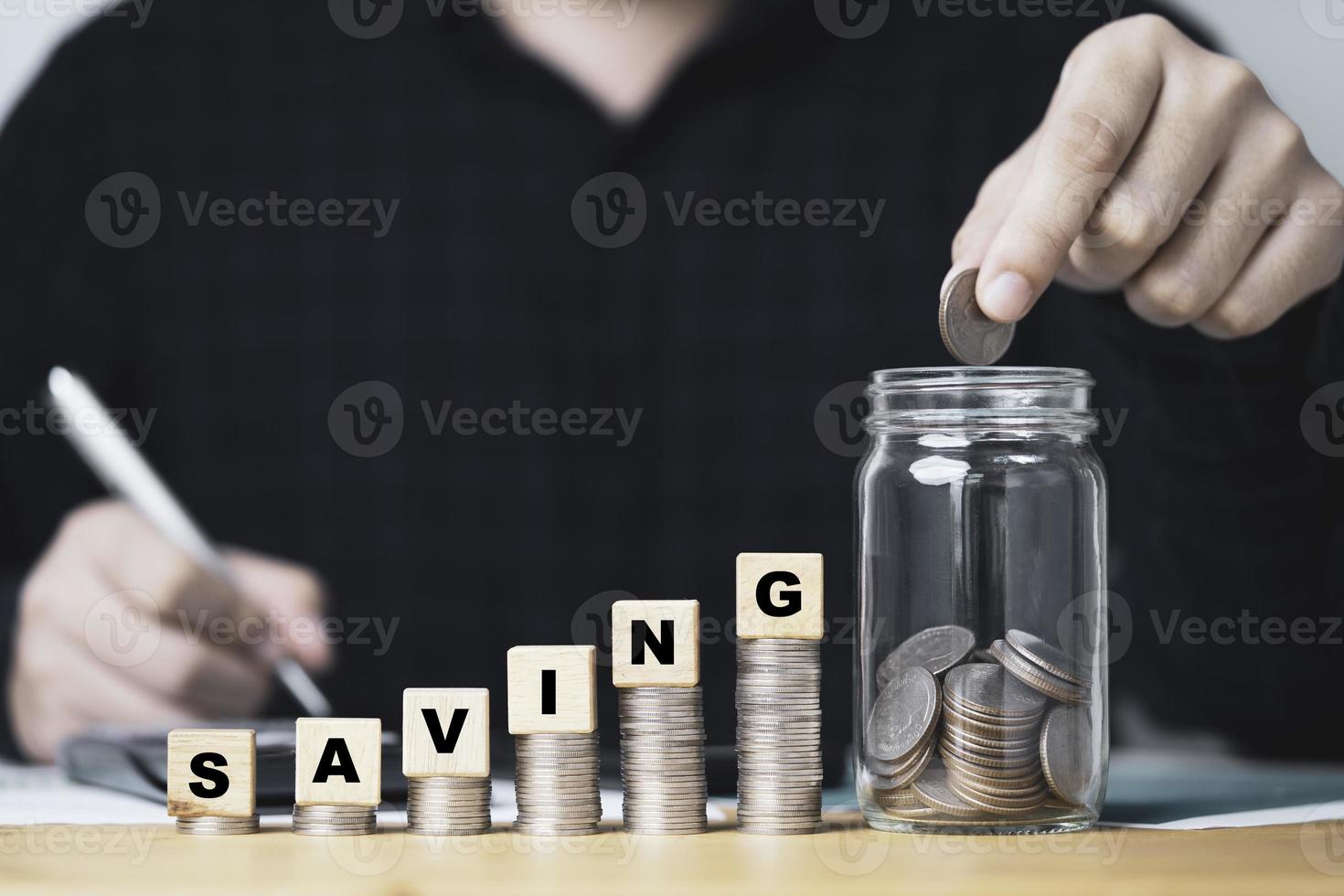 Businessman putting coin to saving jar with increasing coins stacking for deposit money of investment concept. photo
