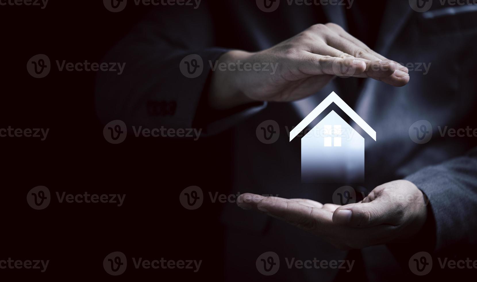 Businessman hand protecting virtual house for real estate property insurance concept. photo