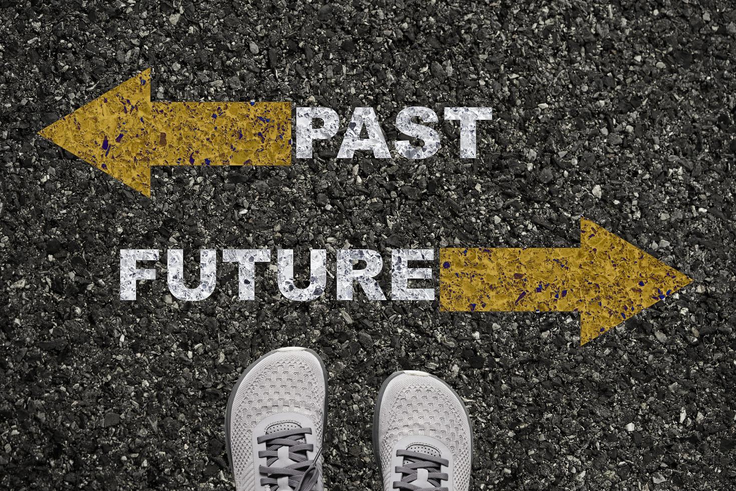 Shoes on asphalt road with yellow opposite arrow and past future wording concept. photo