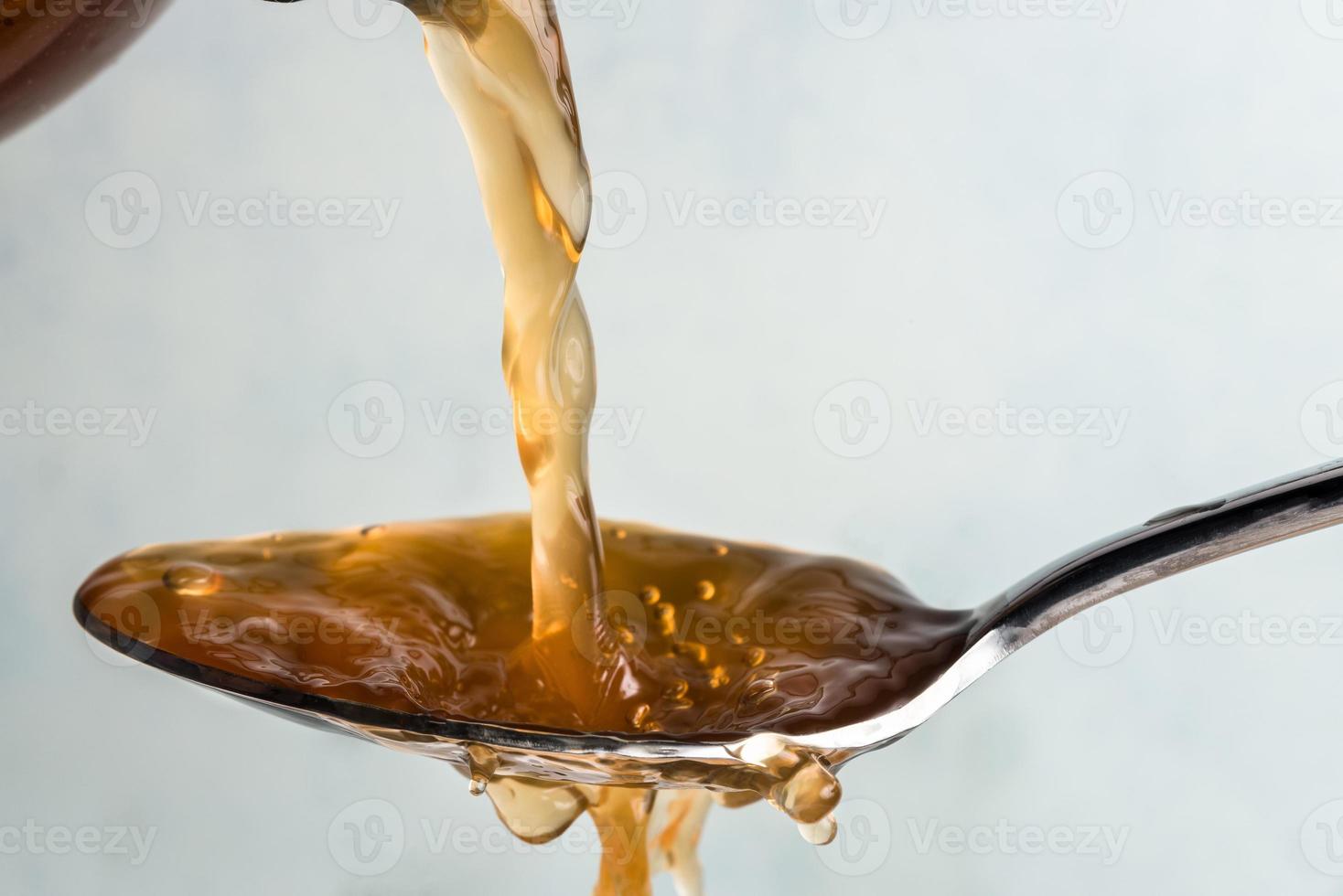 Pouring Apple Cider Vinegar on a Spoon photo