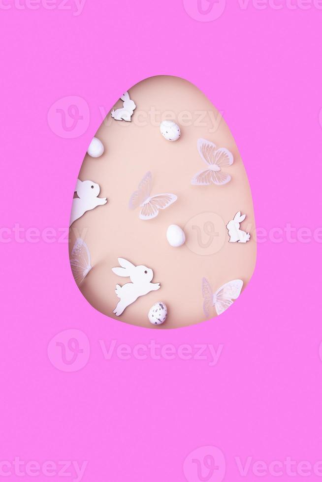 Easter egg cut out of paper and eggs, bunny and butterflies. Creative Easter holiday concept with copy space photo