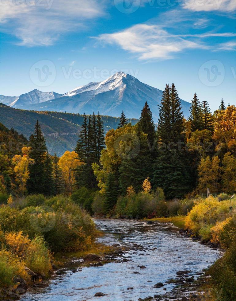 hermoso color otoñal en las montañas elk de colorado. río de cristal y montaña silla. foto