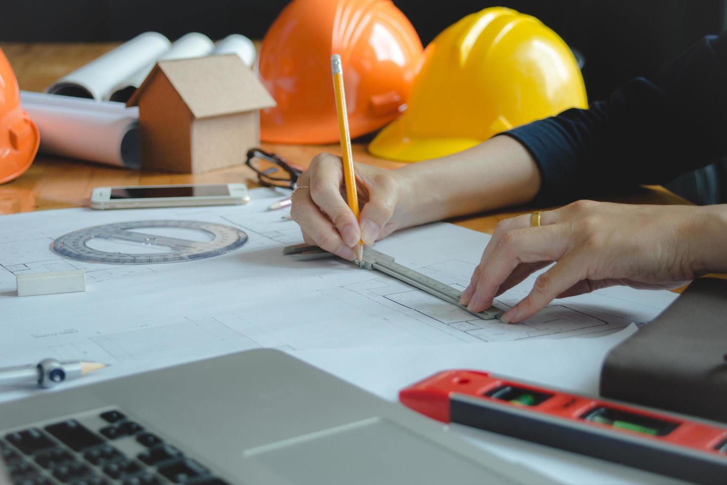 Hands of architect or engineer using drawing compass with blueprint on desk in office.Team of architects engineer discussing and check documents and business workflow.Construction concept. photo