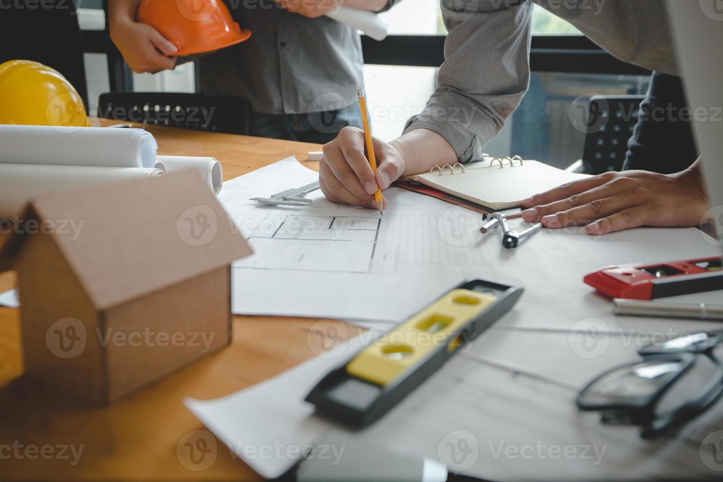 Hands of architect or engineer using drawing compass with blueprint on desk in office.Team of architects engineer discussing and check documents and business workflow.Construction concept. photo