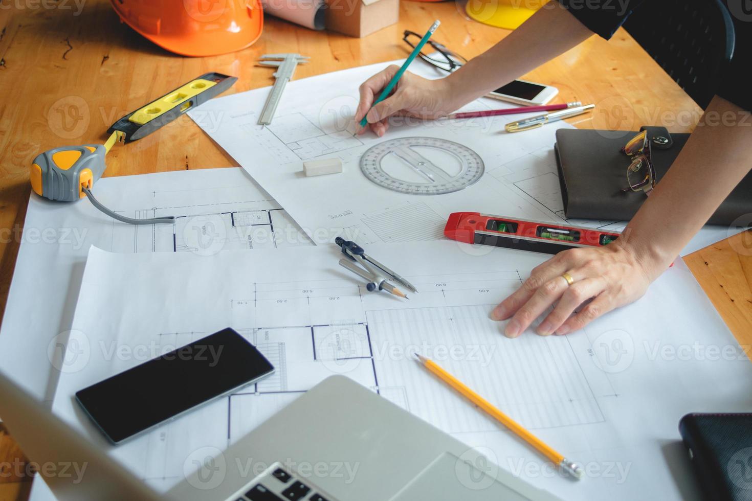 Hands of architect or engineer using drawing compass with blueprint on desk in office.Team of architects engineer discussing and check documents and business workflow.Construction concept. photo