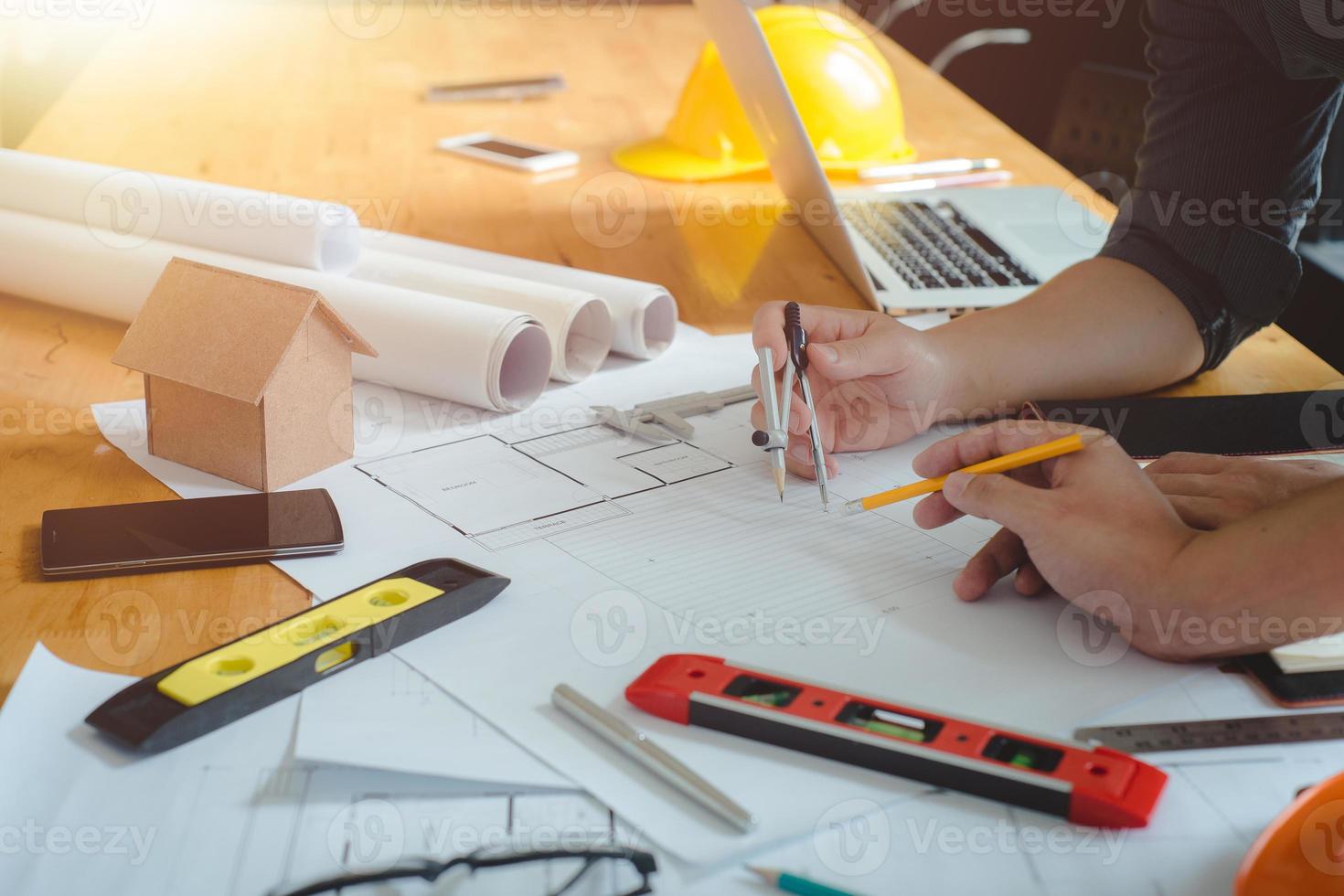 Hands of architect or engineer using drawing compass with blueprint on desk in office.Team of architects engineer discussing and check documents and business workflow.Construction concept. photo