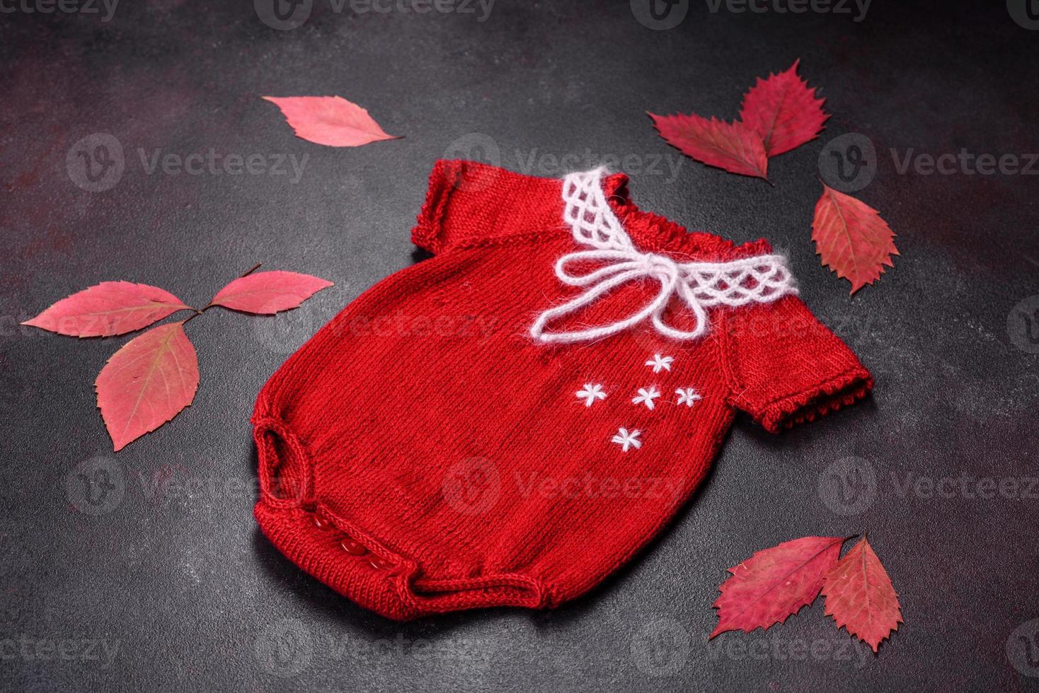 Clothing for a newborn baby knitted from red threads photo