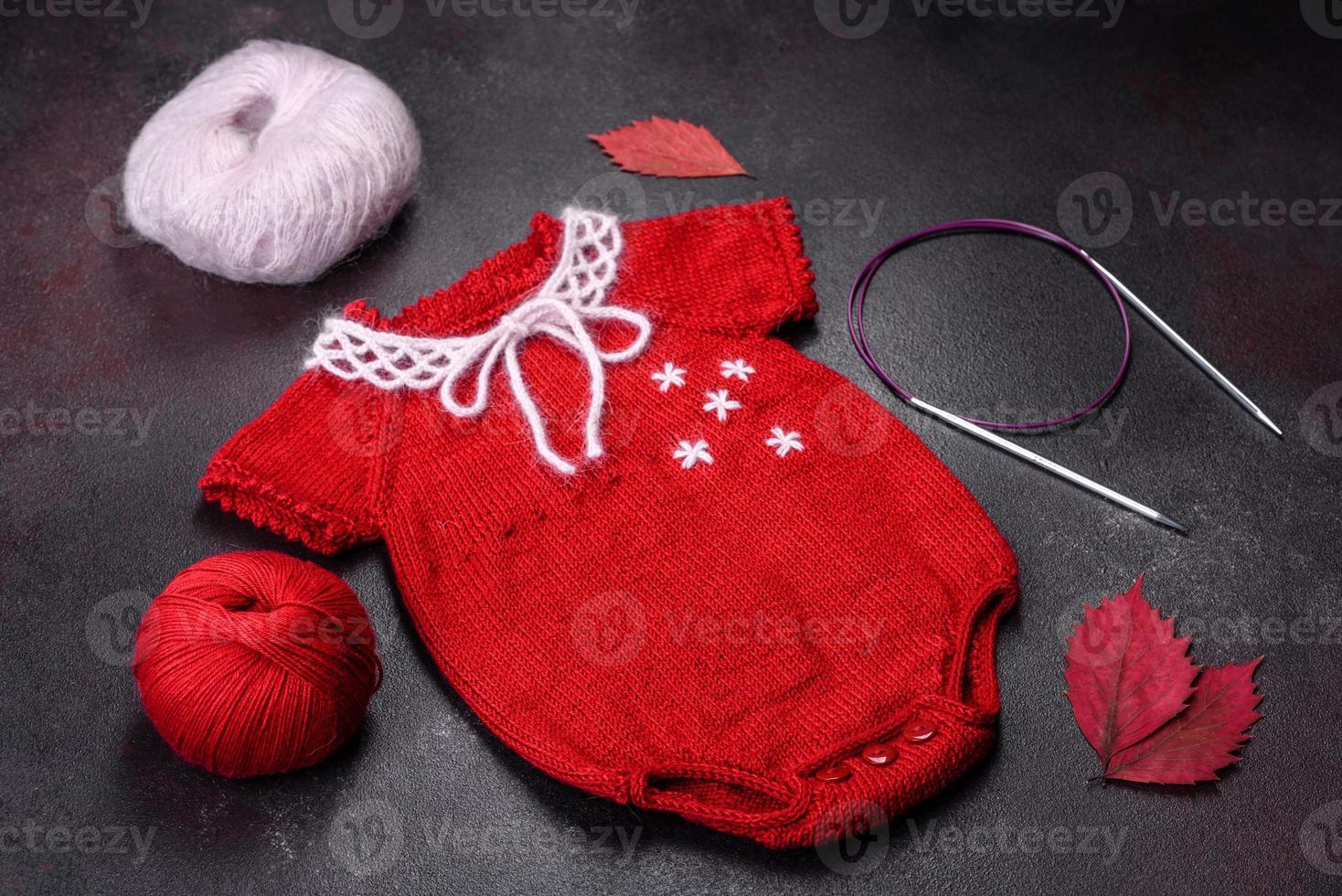 Clothing for a newborn baby knitted from red threads photo