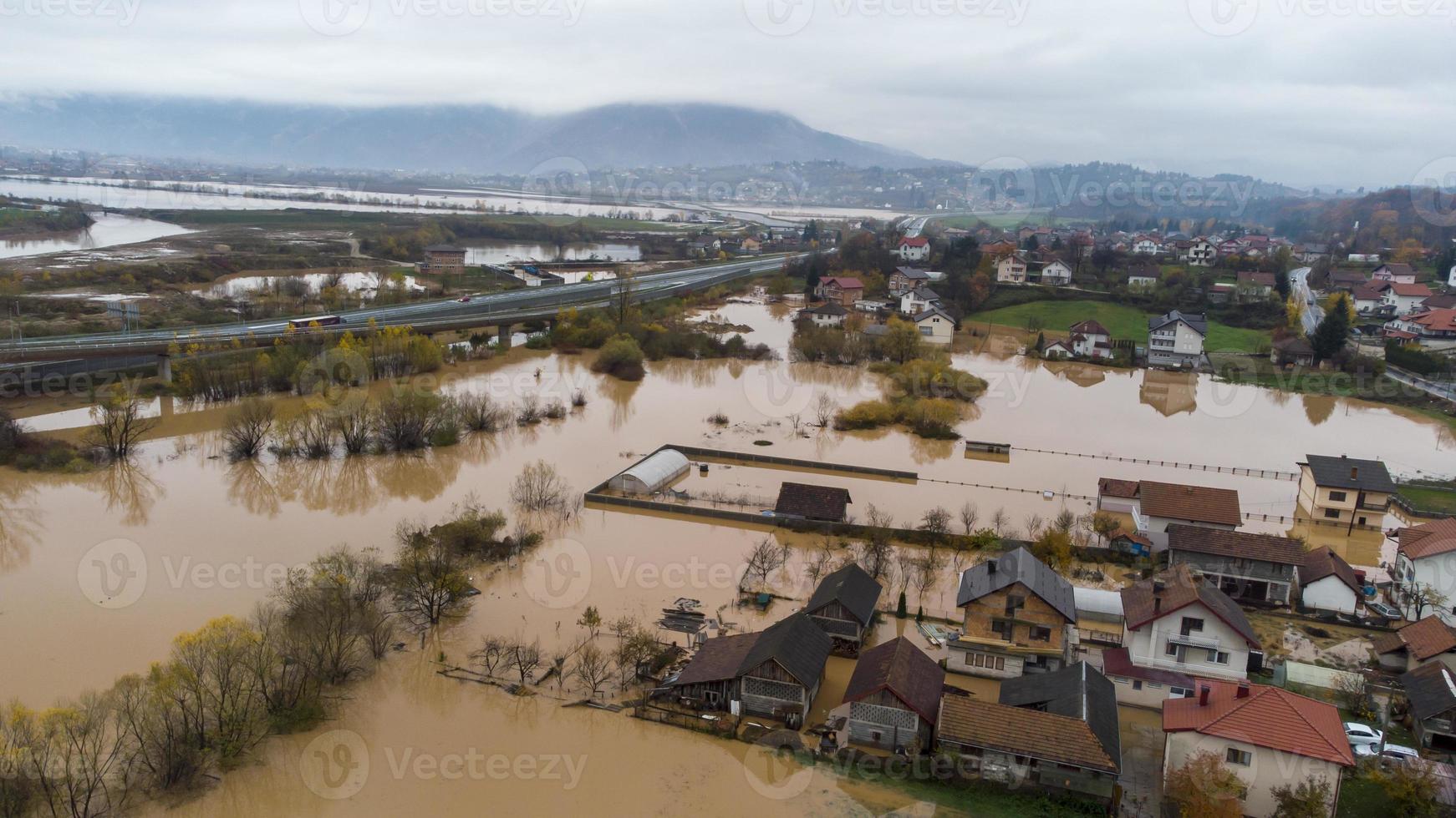 Aerial drone view of torrential rain causes flash floods in residential areas. Houses and roads surrounded by water. Climate change. Heavy rainfall consequences. photo