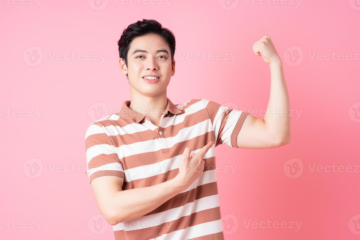 joven asiático posando sobre fondo rosa foto