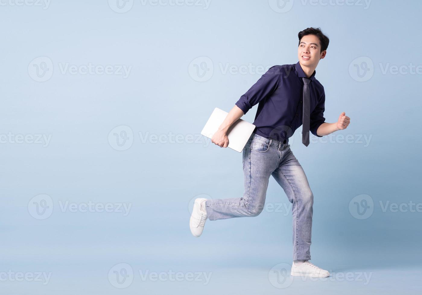 Full length image of young Asian businessman on blue background photo