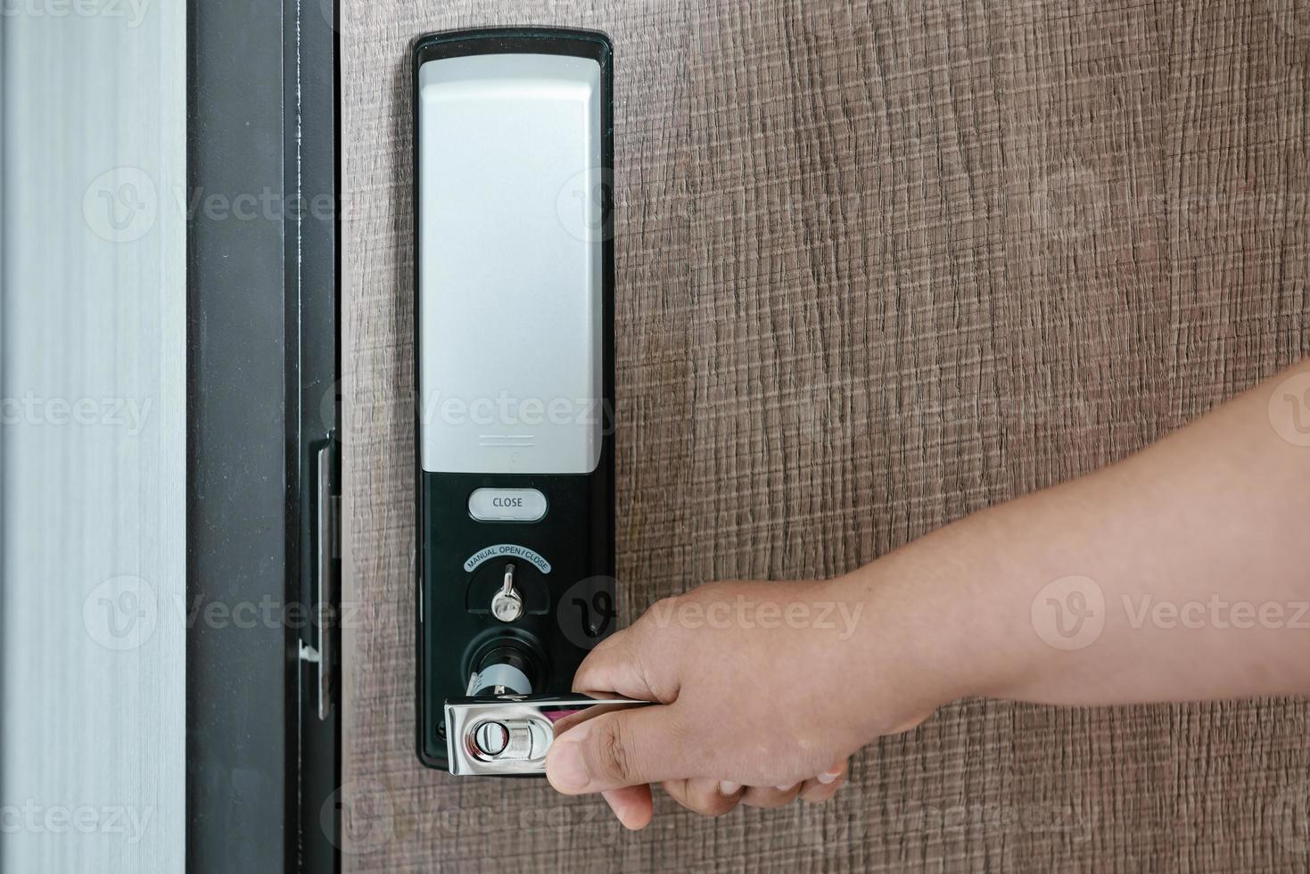 la mano de la mujer sostiene el mango de la puerta mientras abre una puerta para acceder al edificio de apartamentos. puerta eléctrica con código de teclado para sistema de seguridad en habitación de apartamentos. puerta electrónica para entrada-salida de edificio. foto