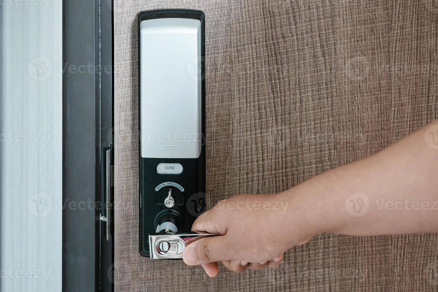 Woman Hand is Holding Door Handle While Opening a Door for Access Apartment Building. Electric Door With Keypad Code for Security System in Apartments Room. Electronic Door for Entrance-Exit Building. photo