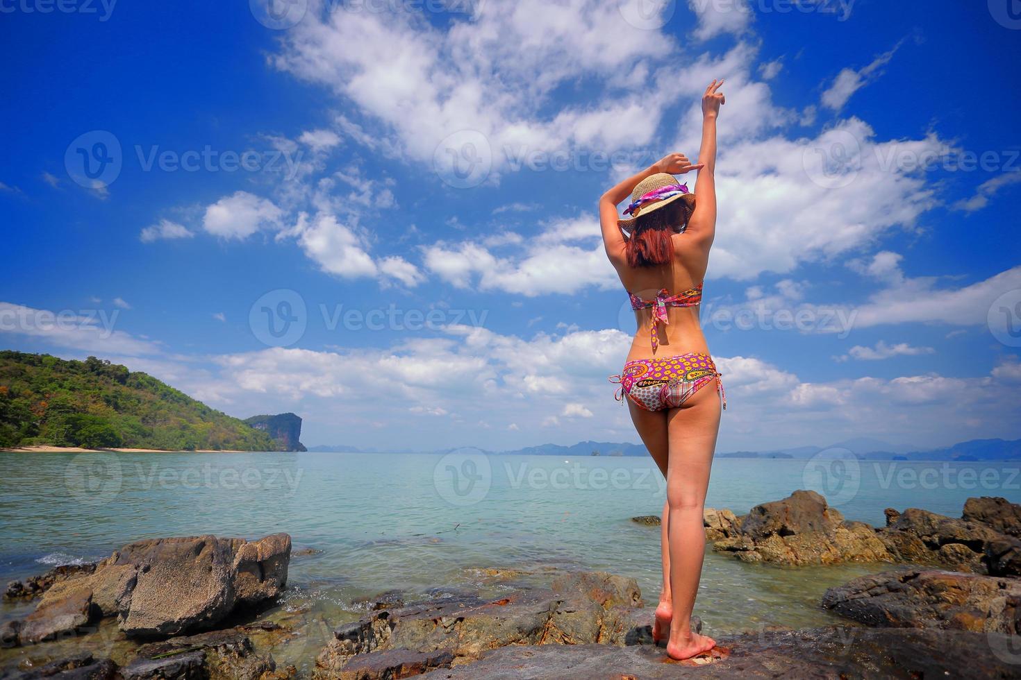 Free action and relaxing of bikini tanned girl on white sand beach at Krabi, Thailand. Concept image for summer vacation in tropical country. photo