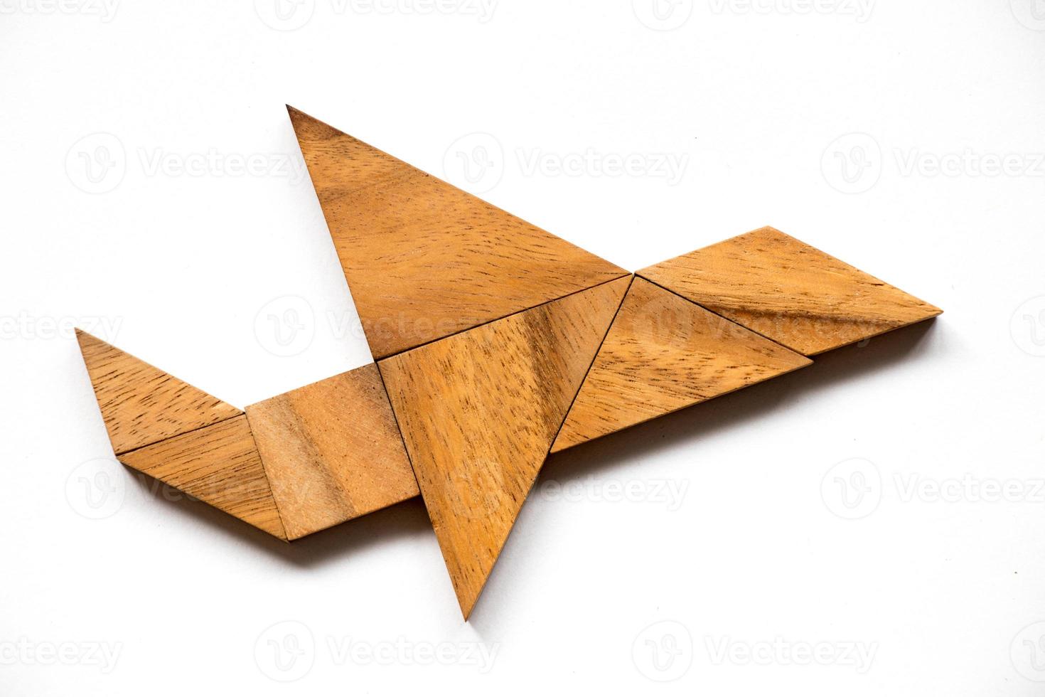 Tangram de madera en forma de avión sobre fondo blanco. foto