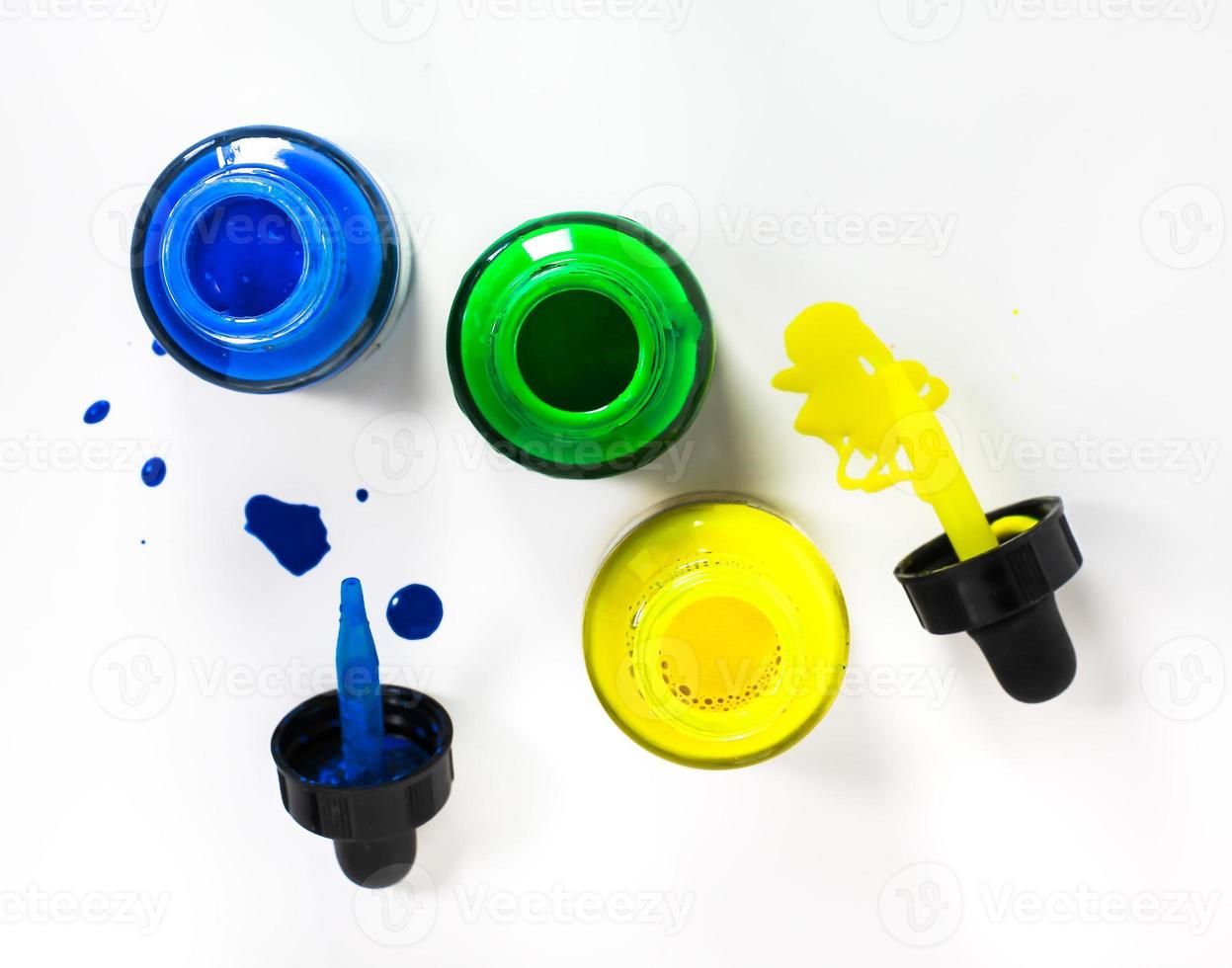 Glass bottle with acrylic paint on white background photo