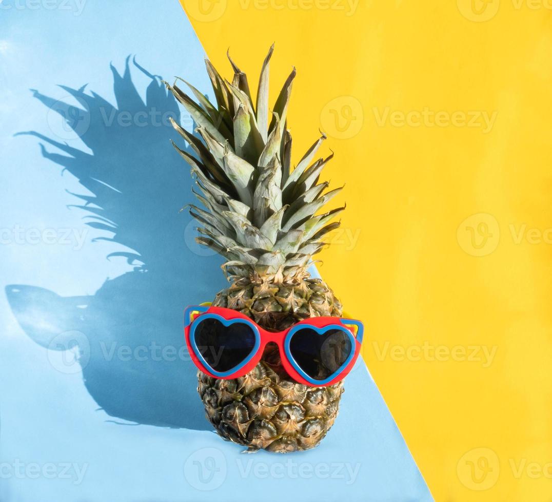 hipster de piña en gafas de sol. concepto mínimo, piña tropical de verano. foto