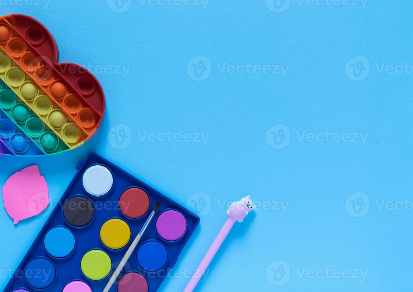 Back to school concept. School and office supplies on the office table and antistress toy. Flat lay photo