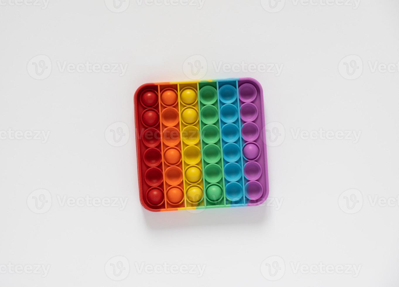Colored toy antistress for kids pop it. Square with rainbow colors isolated on white background. photo