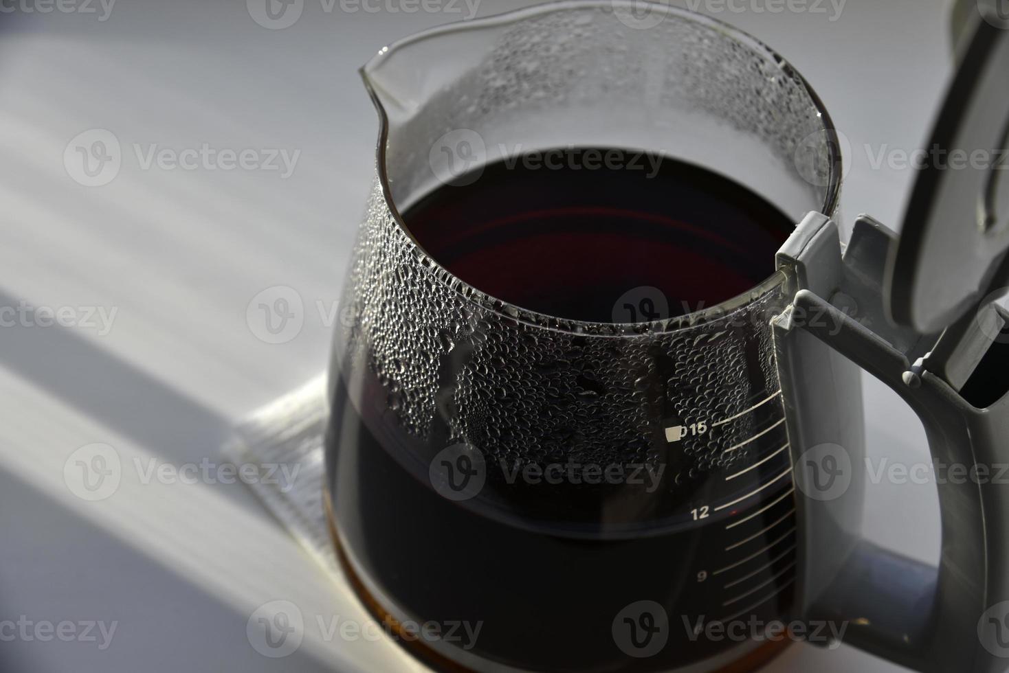 Glass coffee jug with a drink on a white background photo