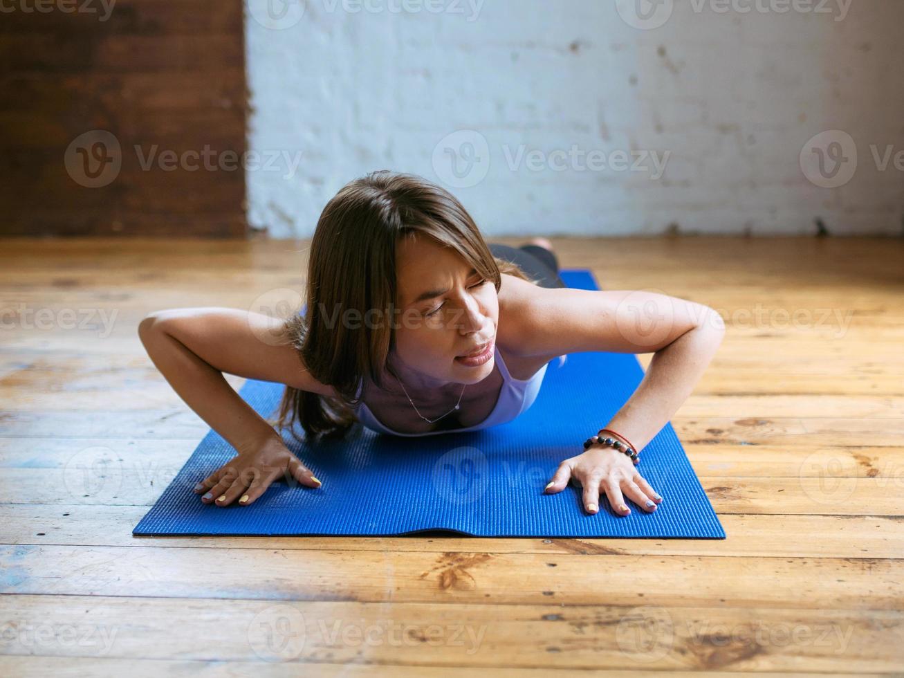 young fit woman in sportswear starting yoga and have troubles with yoga asanas indoor. Yoga and sport concept photo