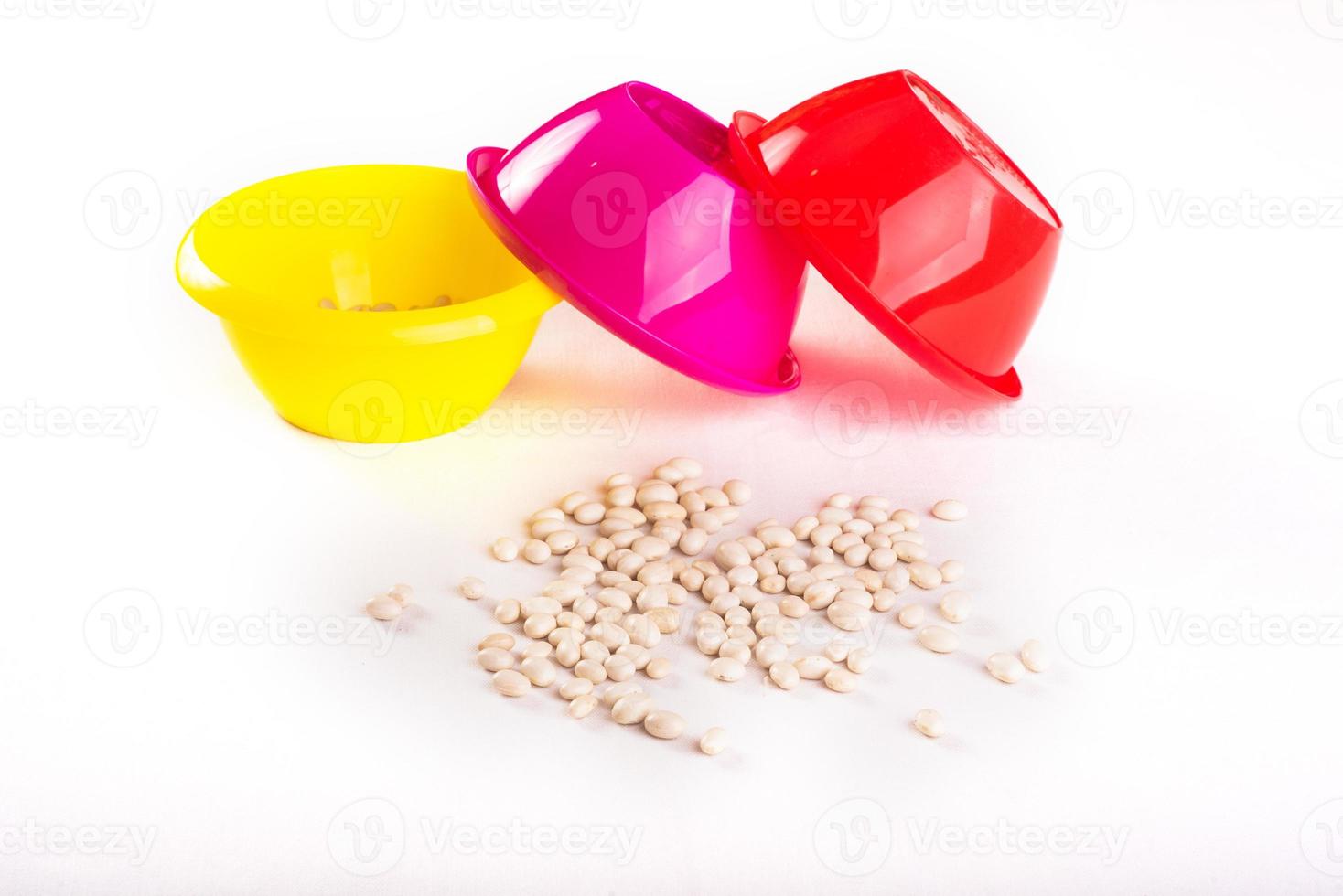 Developing lessons for young children. The development of fine motor skills. Haricot, beans and colored plastic bowl photo