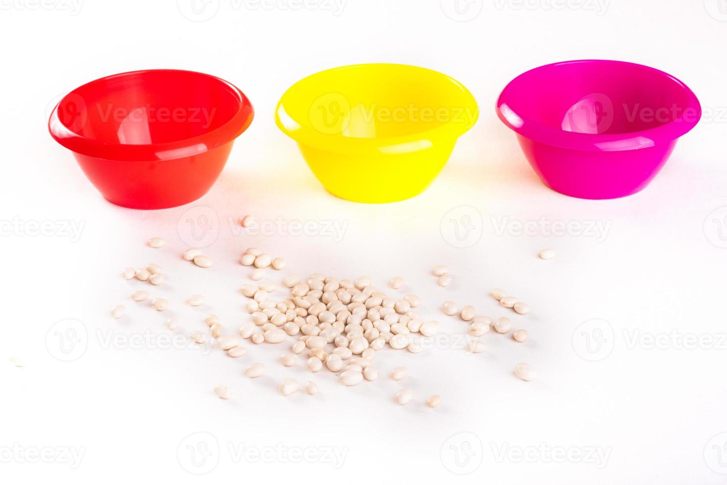 Developing lessons for young children. The development of fine motor skills. Haricot, beans and colored plastic bowl photo