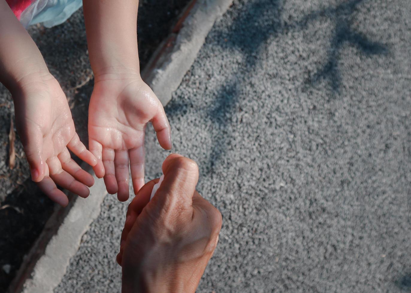 Child's hand was drenched with an alcohol spray. photo