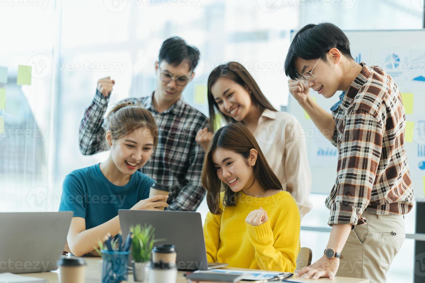 éxito y concepto ganador, equipo de negocios asiático feliz celebrando la victoria en el cargo. foto