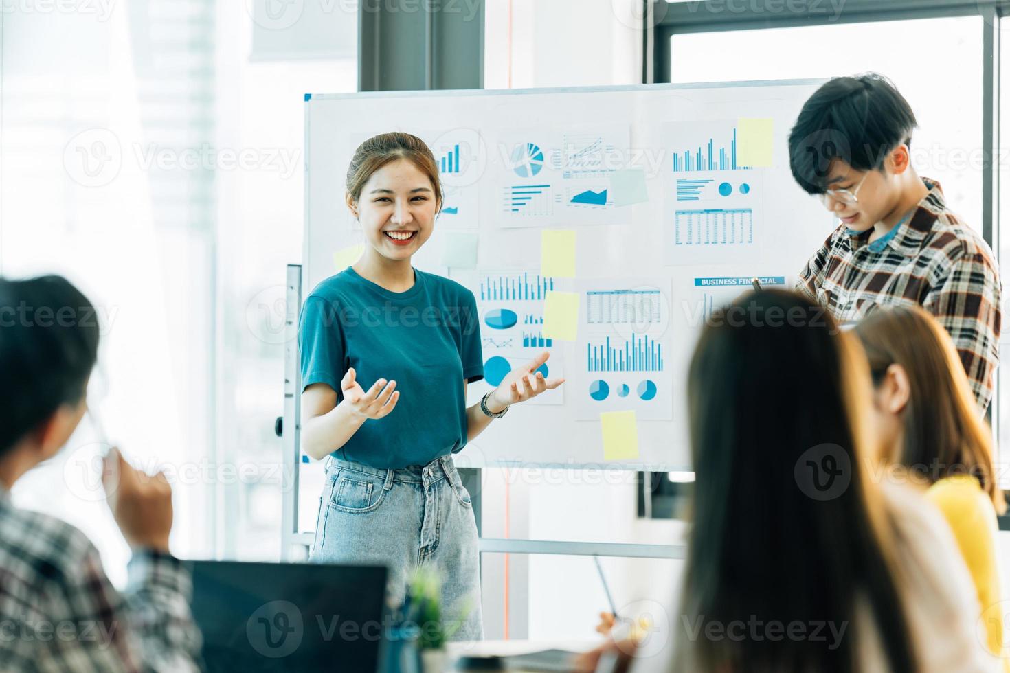 grupo de cuatro felices jóvenes compañeros de equipo de personas corporativas asiáticas que se reúnen para discutir negocios en la oficina. foto