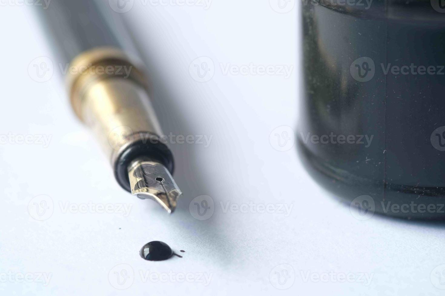 ink, empty paper and fountain pen on table photo