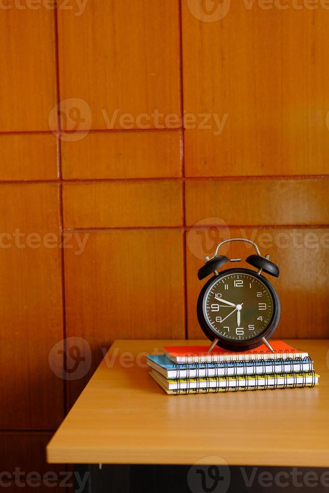 pila de bloc de notas y reloj en la mesa con espacio de copia foto