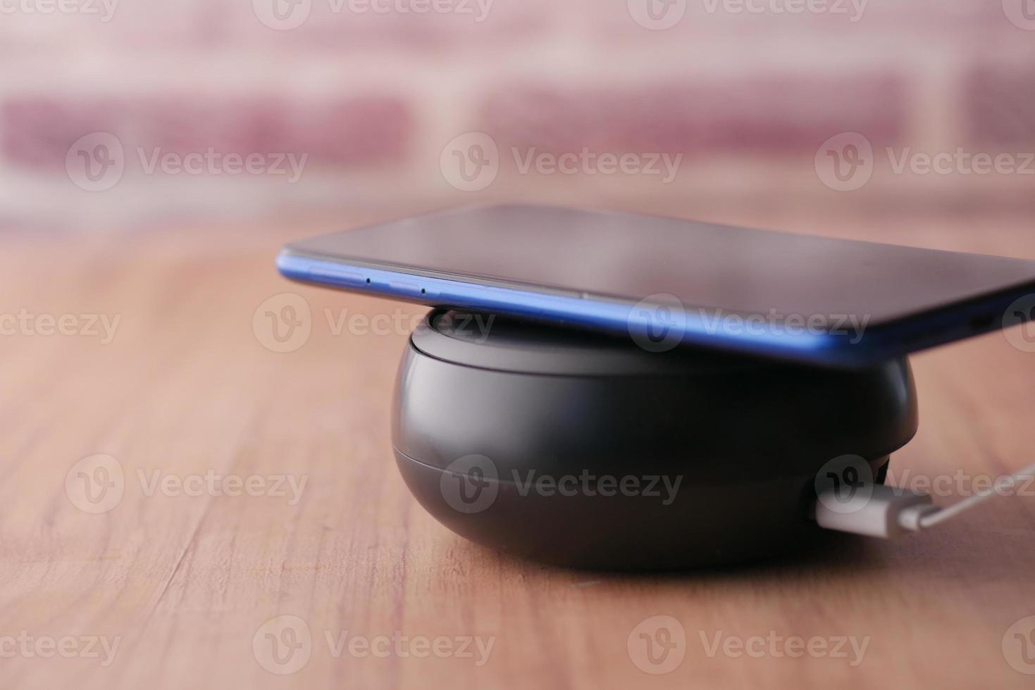 charging Smartphone using Wireless Charging Pad, top view photo