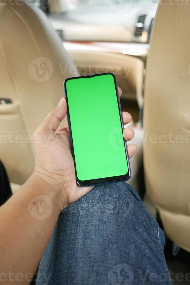 hand holding smart phone with empty screen in a car photo