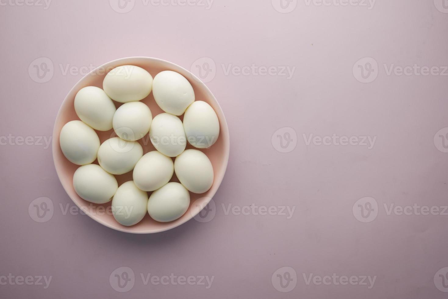 top view of bowel egg in a bowl on purple background photo