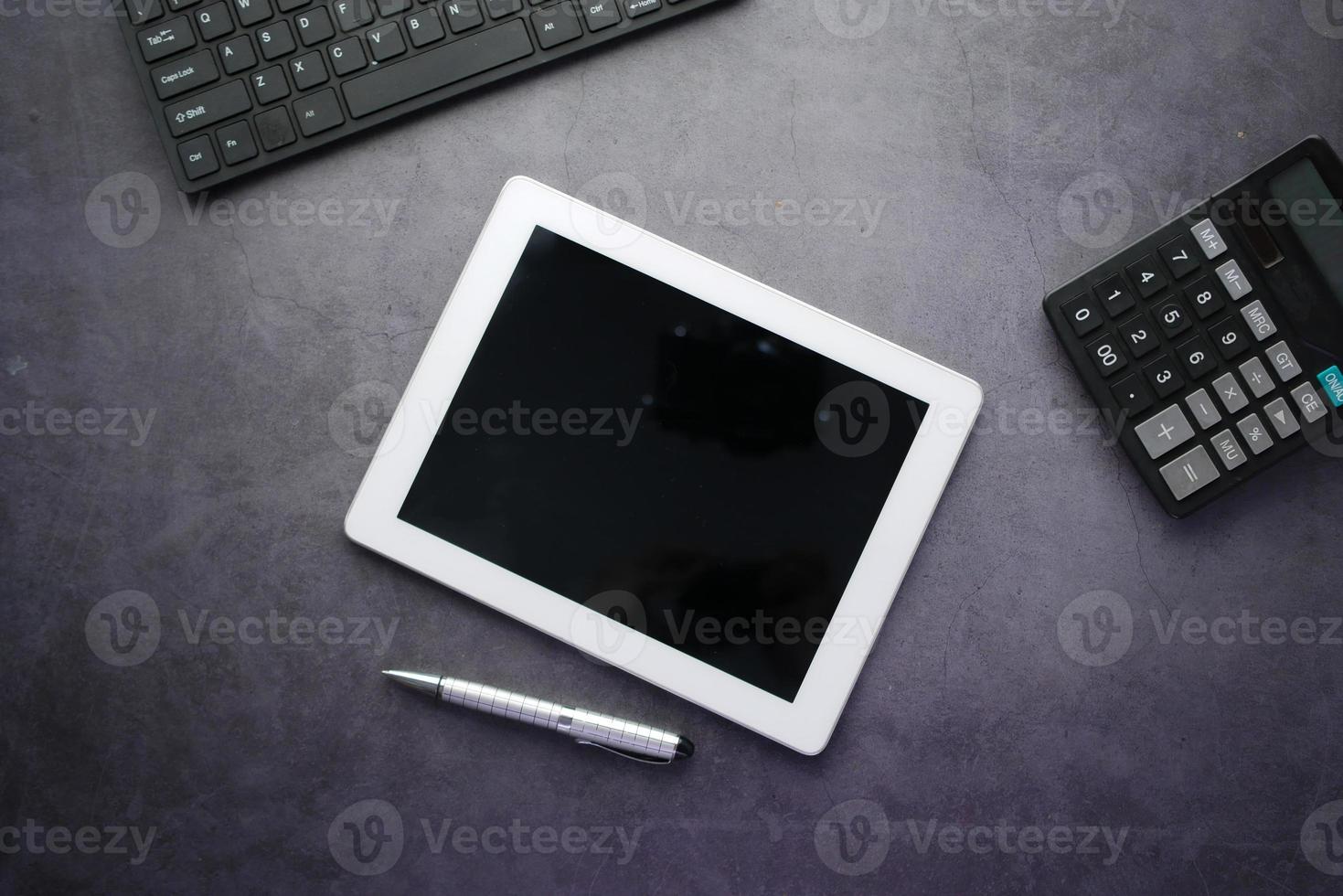 top view of digital tablet with office suppliers on black background photo