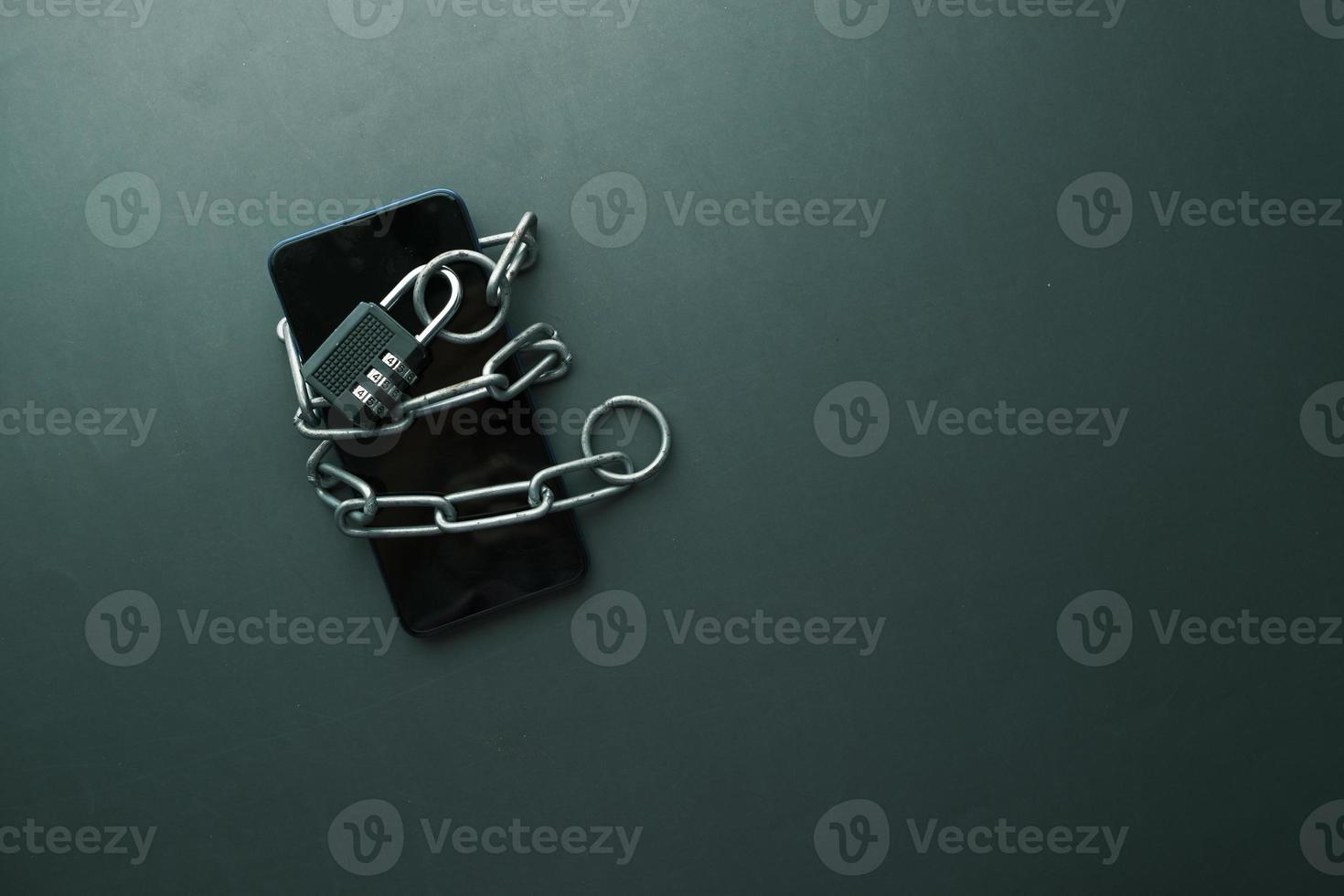Smart Phone With Padlock And Chain Over black Background. photo