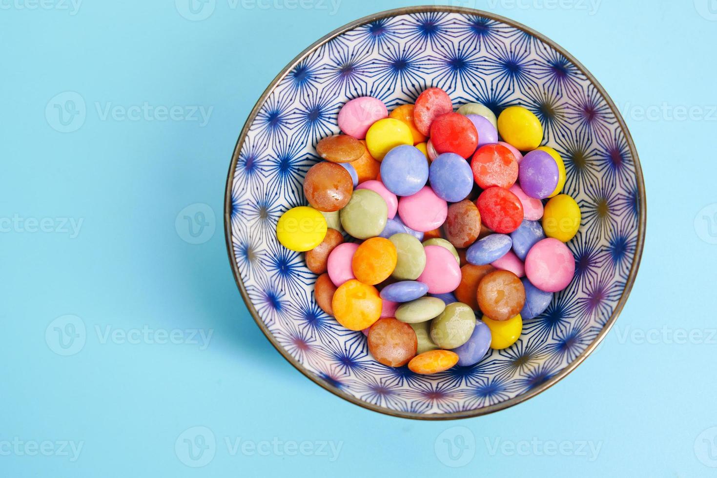 Caramelos dulces multicolores en un recipiente de cerca foto