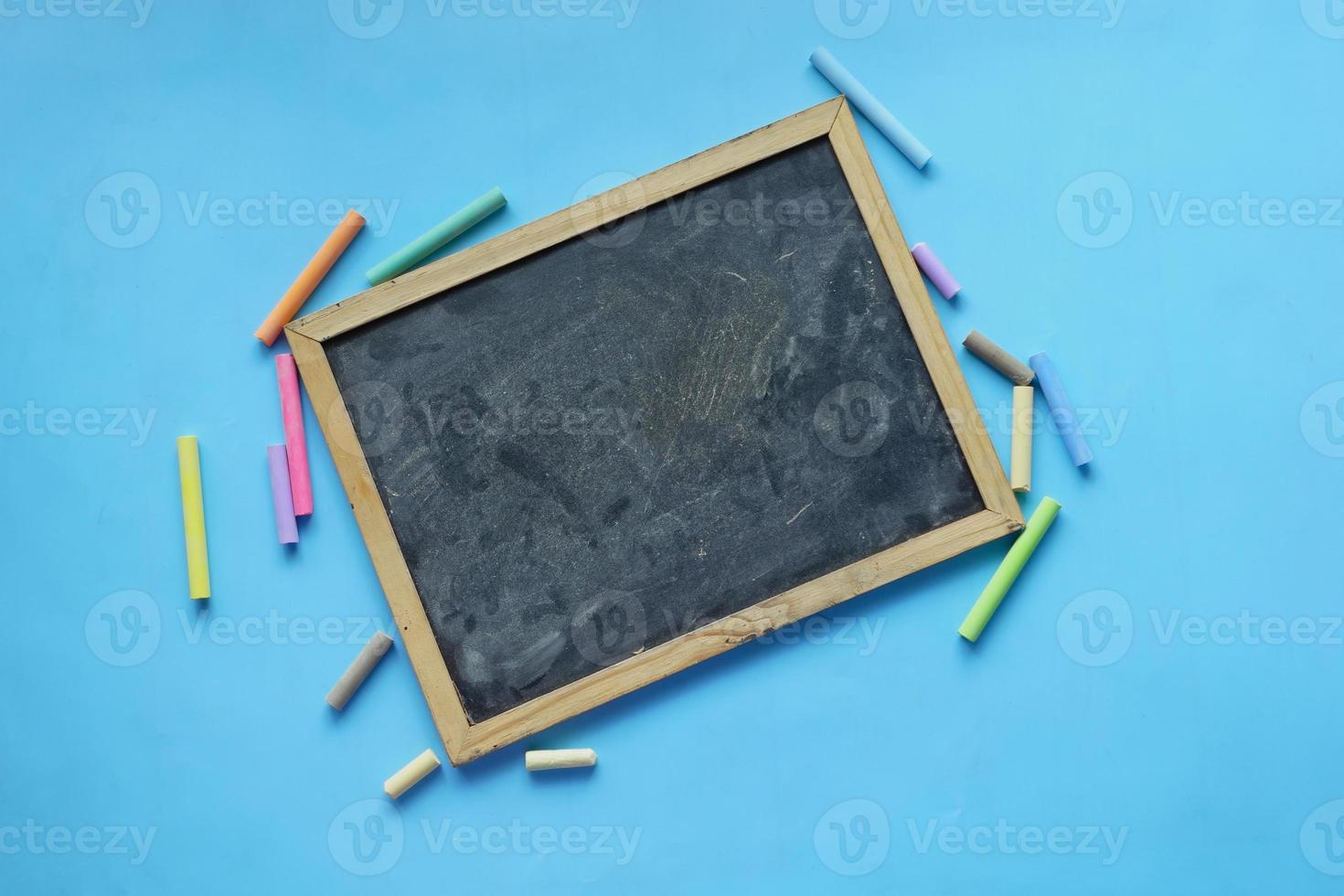 A black chalk board on blue background top view photo