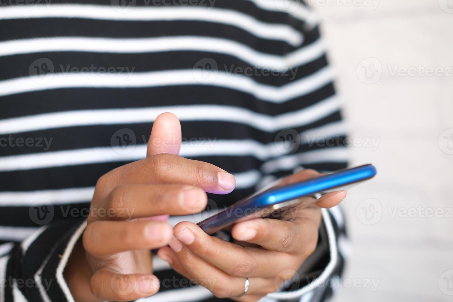 Cerca de la mano del hombre joven con teléfono inteligente. foto