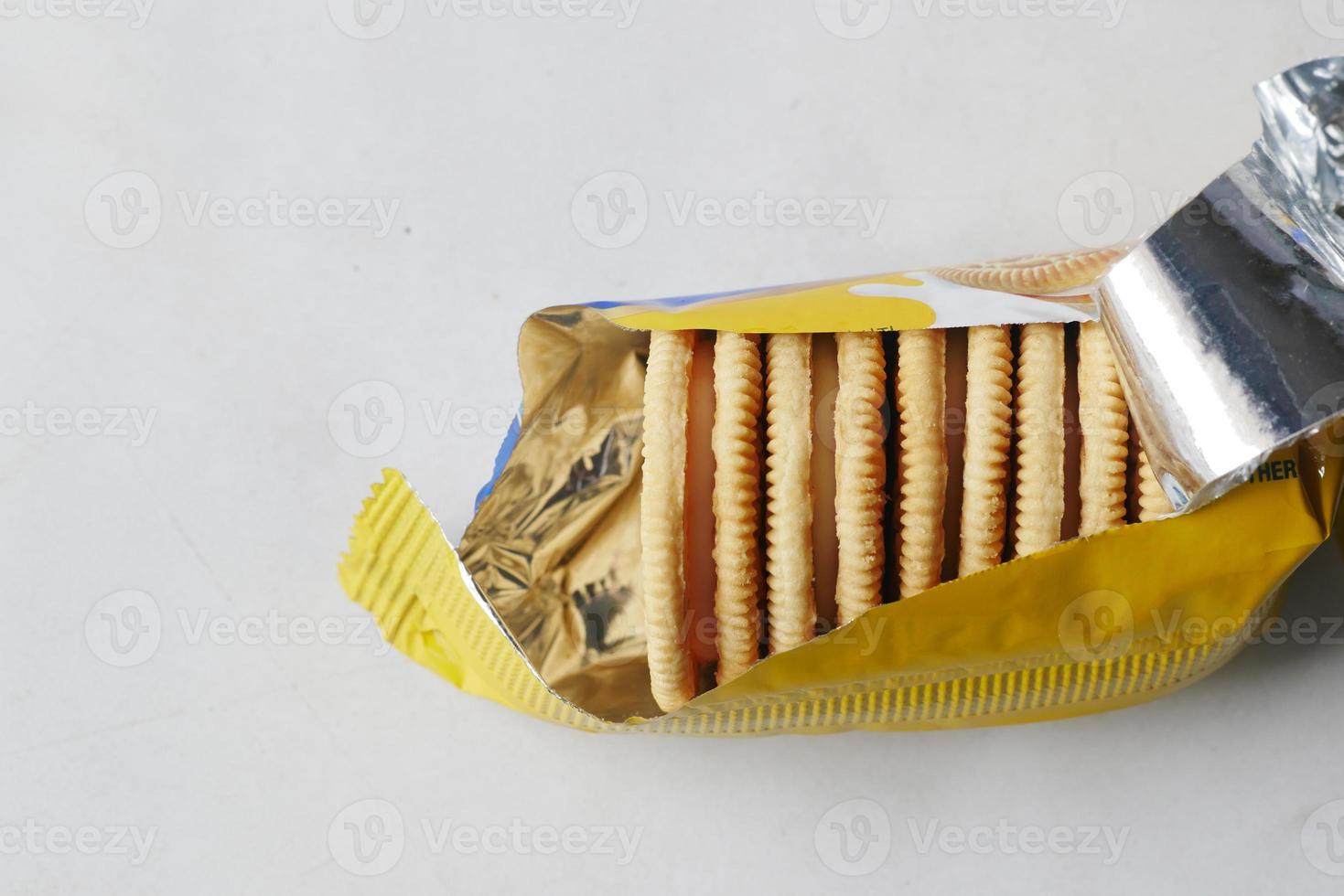 top view of sweet cookies in a plastic packet on wooden table photo