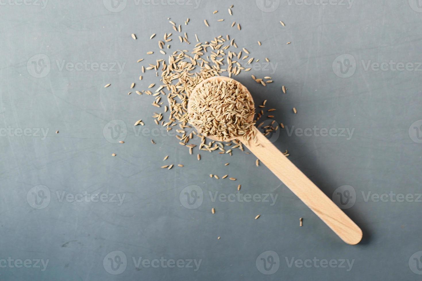 cumin seeds on spoon on table , top view photo