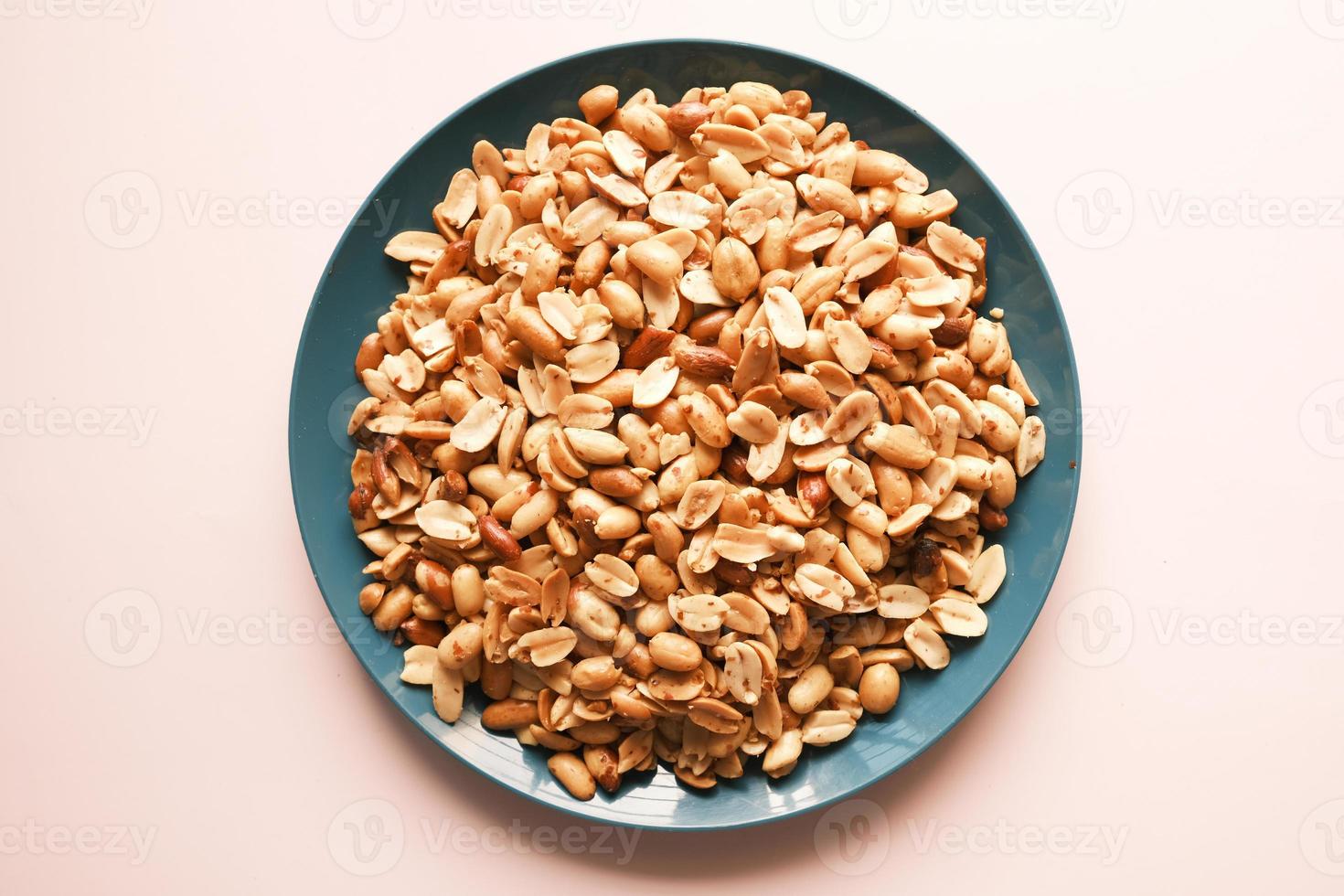 Processed pea nuts in a bowl on table top down . photo