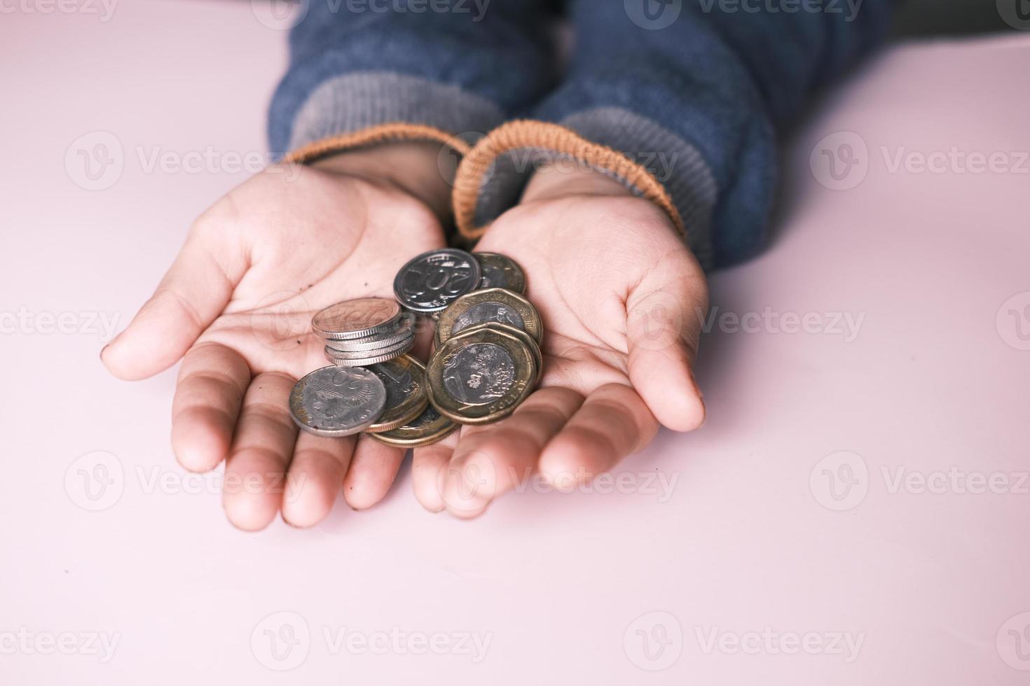 Cerca de monedas en la palma de la mano de un niño foto