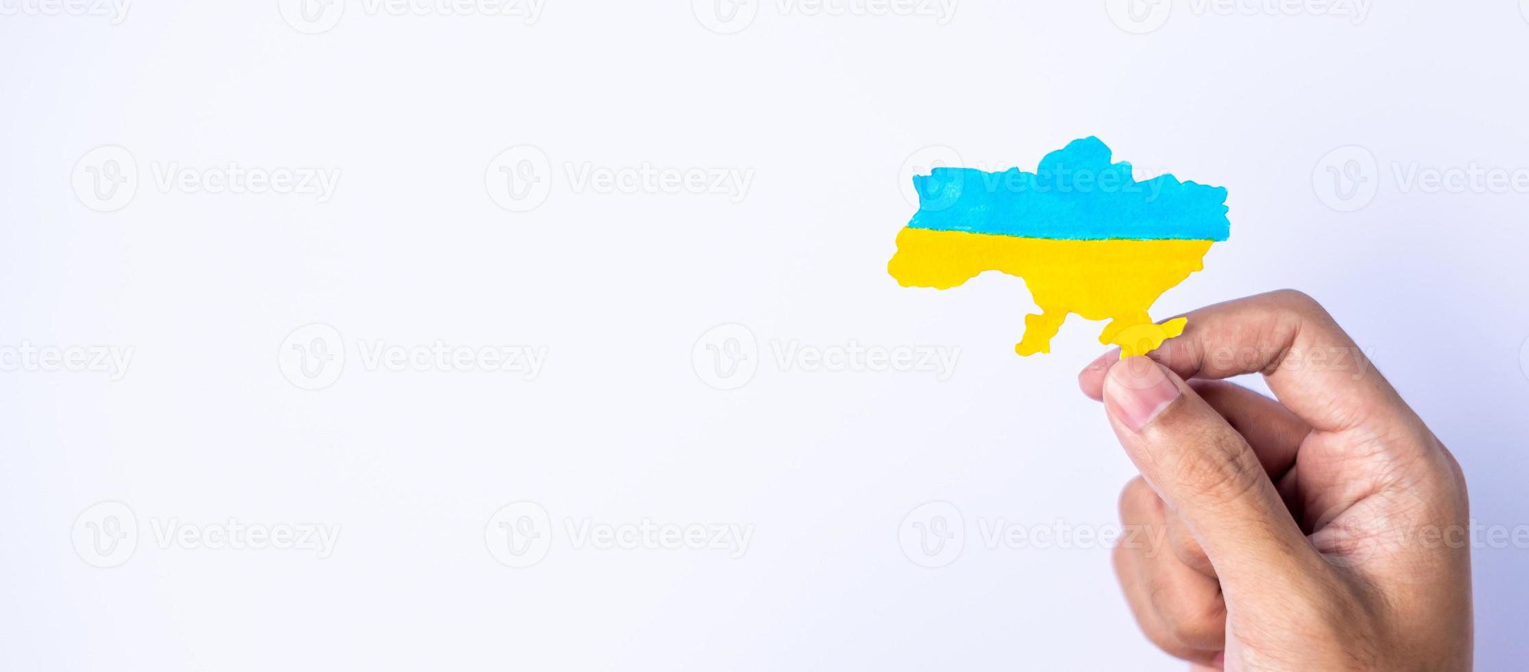 apoyo a ucrania en la guerra con rusia, manos sosteniendo la forma de la frontera de ucrania con bandera de color. oren, no a la guerra, detengan la guerra y apoyen a ucrania foto