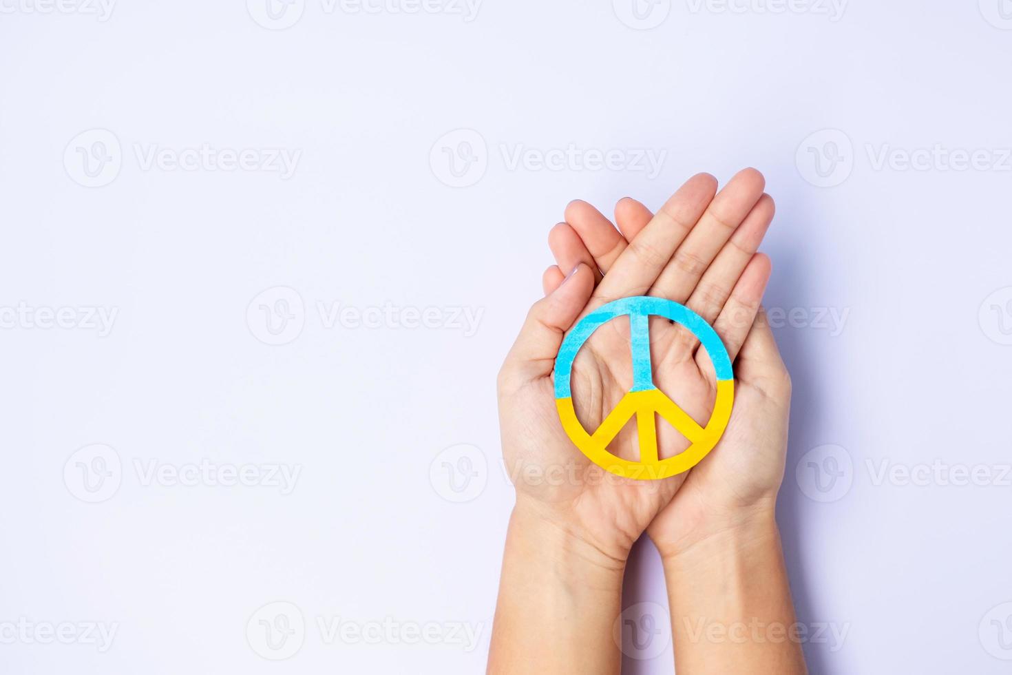 Support for Ukraine in the war with Russia, Hands holding symbol of peace with flag of Ukraine. Pray, No war, stop war, stand with Ukraine and Nuclear Disarmament photo