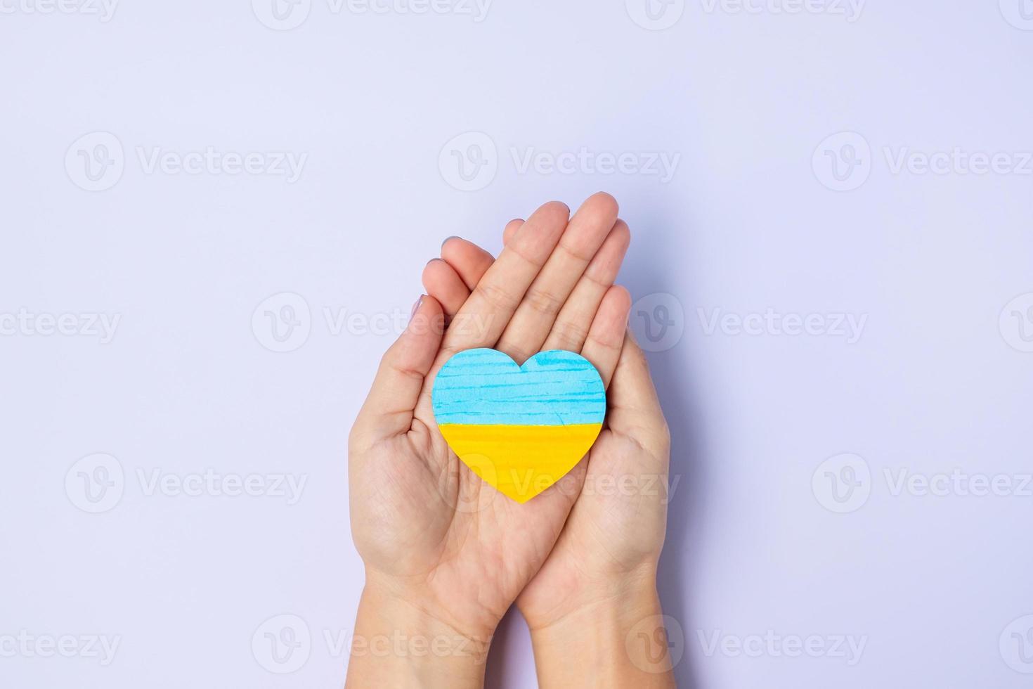 Support for Ukraine in the war with Russia, Hands holding symbol of Heart with flag of Ukraine. Pray, No war, stop war and  stand with Ukraine photo